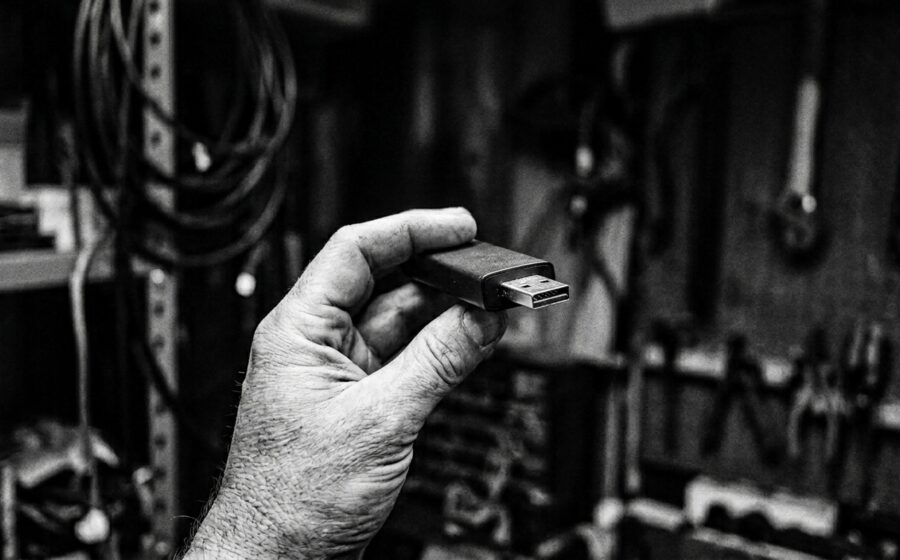 Hand holding streaming stick, forensic documentary photograph