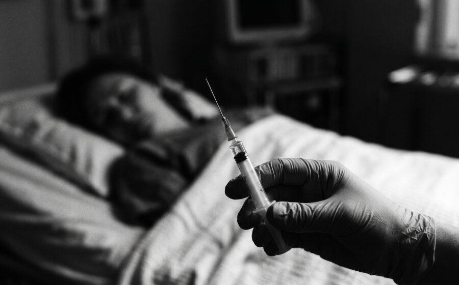 Hand holding a medical syringe, a sleeping figure blurred in the background — the perfect crime, forensic detection gap