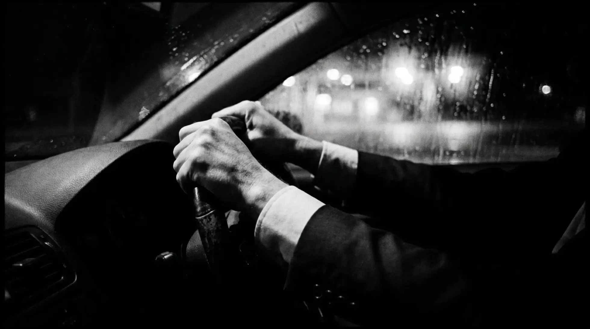 Hands gripping a steering wheel on a rainy night drive, on what the Drach trial showed an expert witness