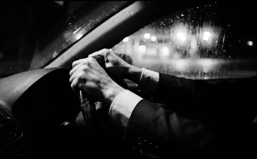 Hands gripping a steering wheel on a rainy night drive, on what the Drach trial showed an expert witness