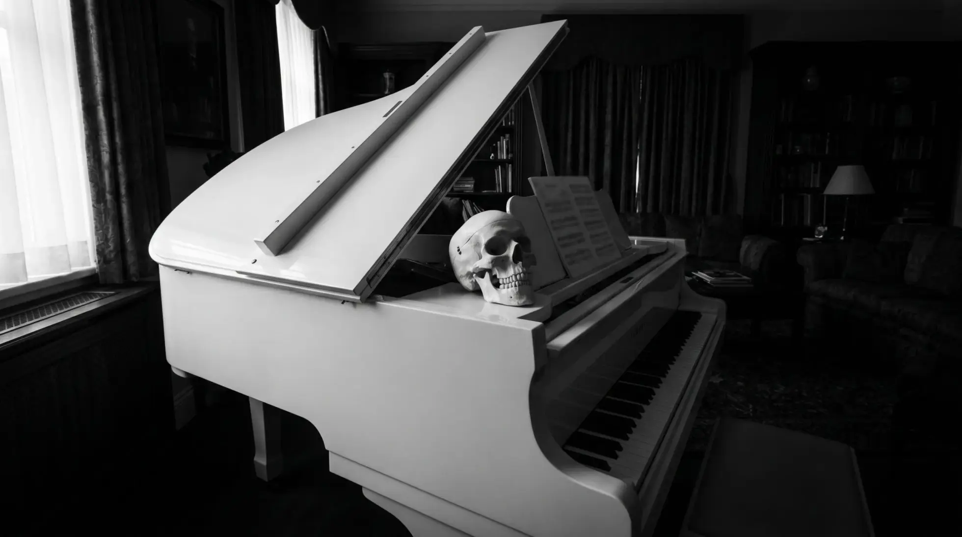 A human skull resting on a white grand piano beside sheet music, opening image on forensic anthropology of the skeleton