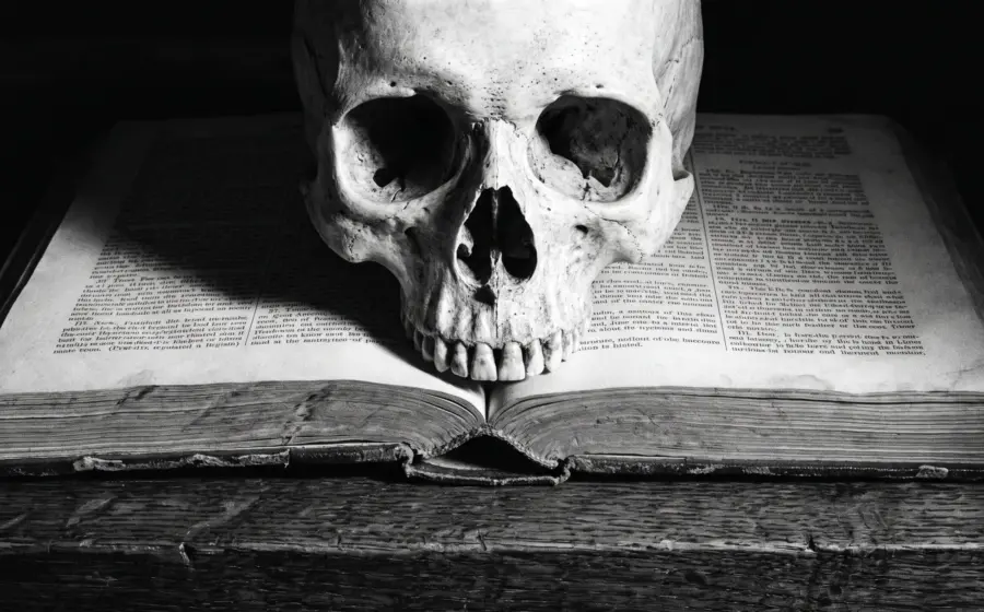 A weathered human skull resting on an open law book, on the legal conditions for owning a real human skull in Germany